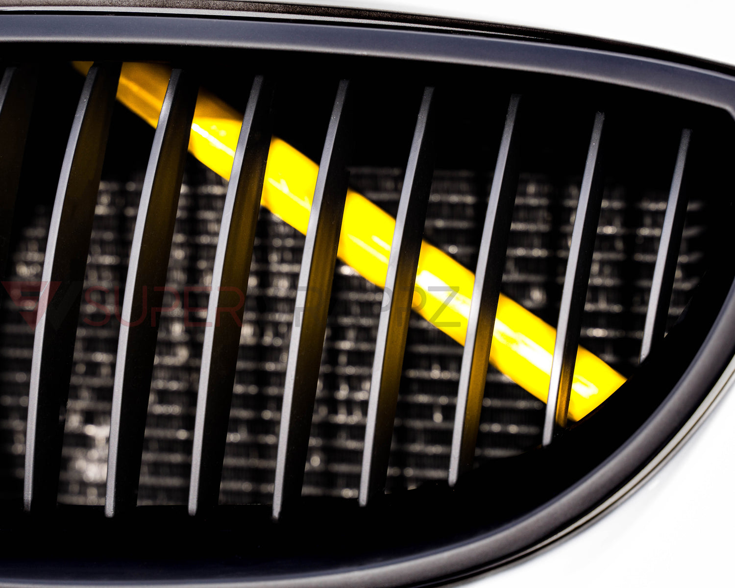 Close-up of a BMW front grille with the yellow reflective V-brace installed