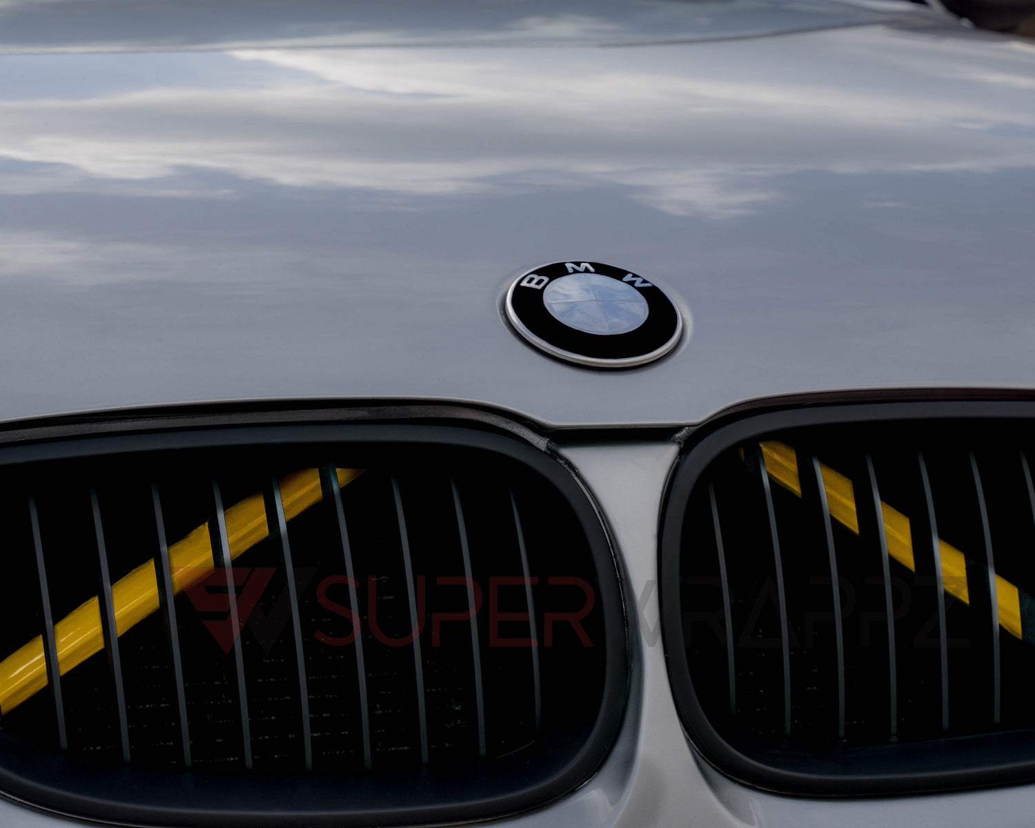 Close-up of a BMW front grille with the yellow reflective V-brace installed