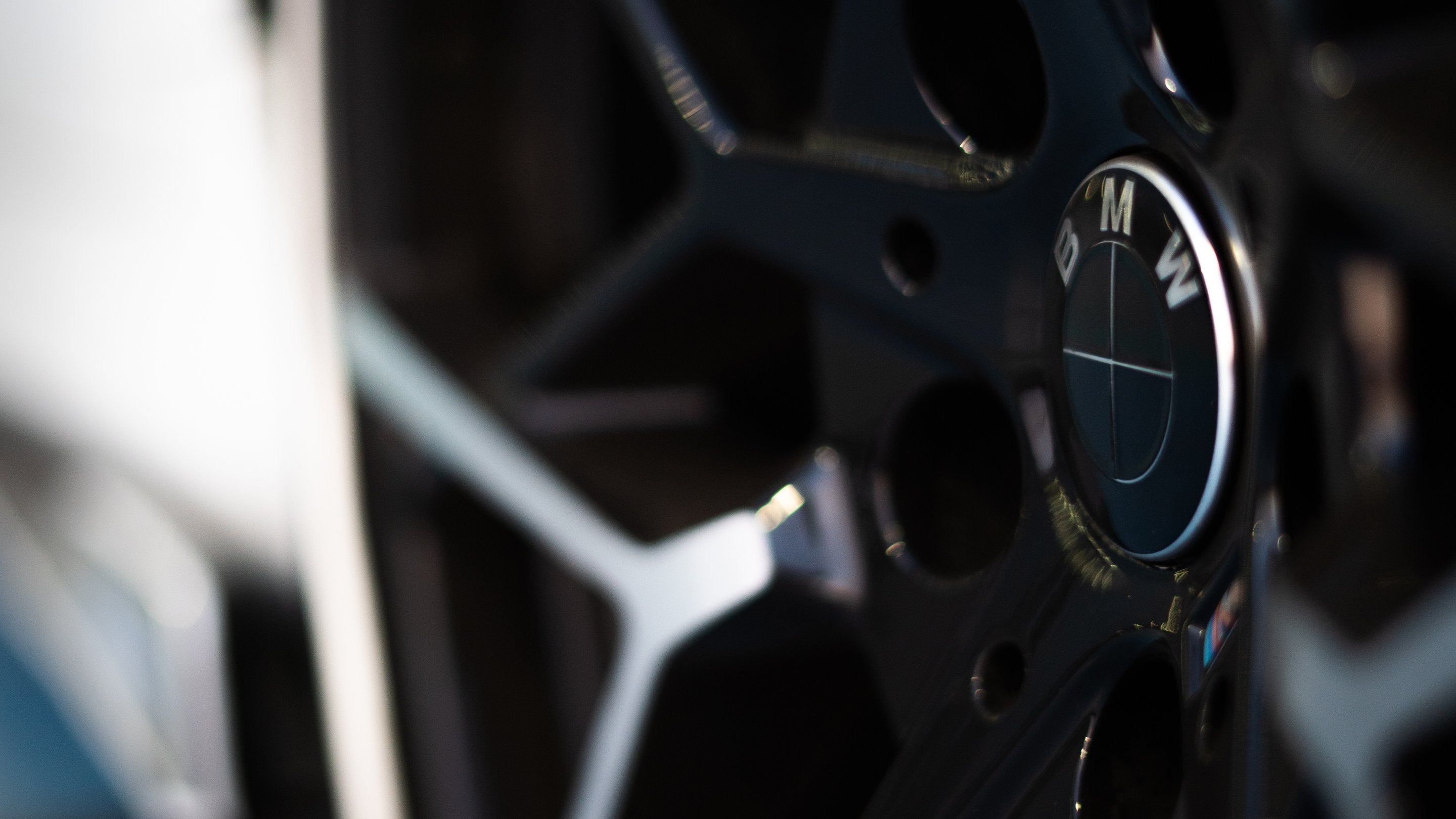 Full Black Gloss BMW badge overlay on a wrapped wheel-cap roundel — Compatible with BMW, not genuine BMW parts