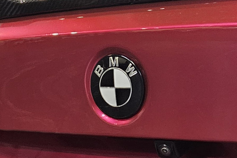 Red BMW G80 M3 boot lid wearing a SuperWrappz blacked-out badge overlay. Compatible with BMW &mdash; Not Genuine BMW Parts.