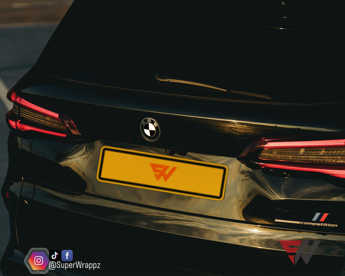 Half Black Gloss V2 BMW badge overlay on the rear boot badge, close-up