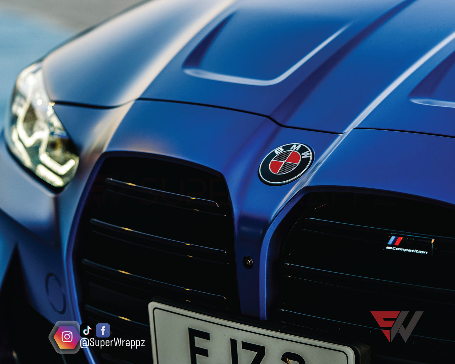 Black and Red Carbon V2 BMW badge overlay by SuperWrappz for F40/G20/G30 2017-plus BMWs, aftermarket cast vinyl