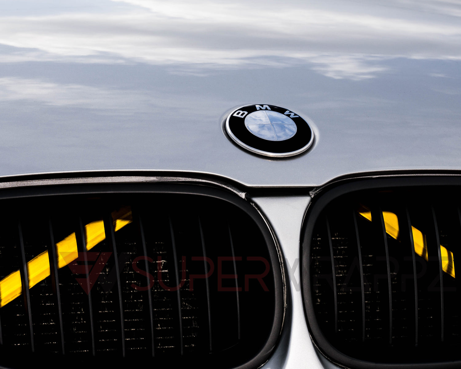 Close-up of a BMW front grille with the yellow reflective V-brace installed