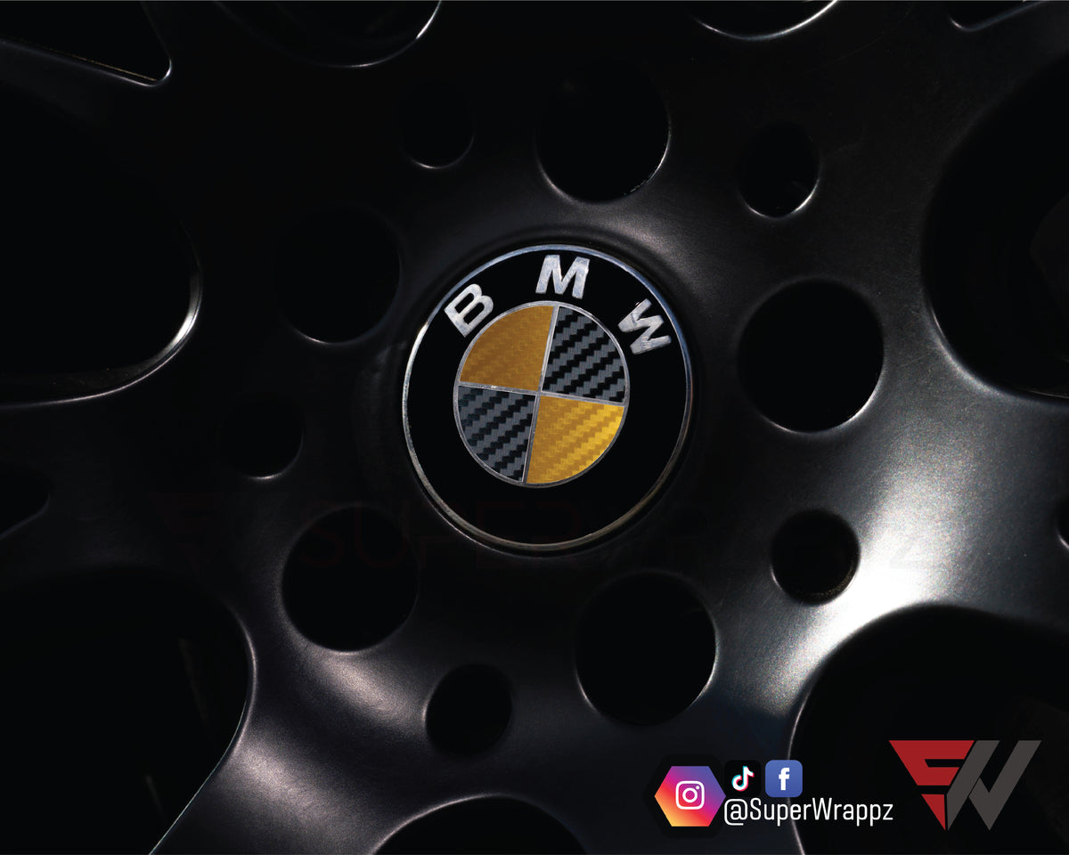 Black & Gold Carbon BMW badge overlay applied to an alloy wheel centre cap, close-up