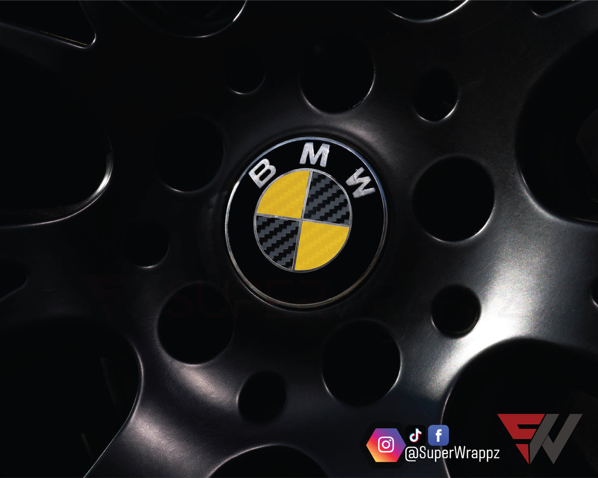 Black & Yellow Carbon BMW badge overlay applied to an alloy wheel centre cap, close-up