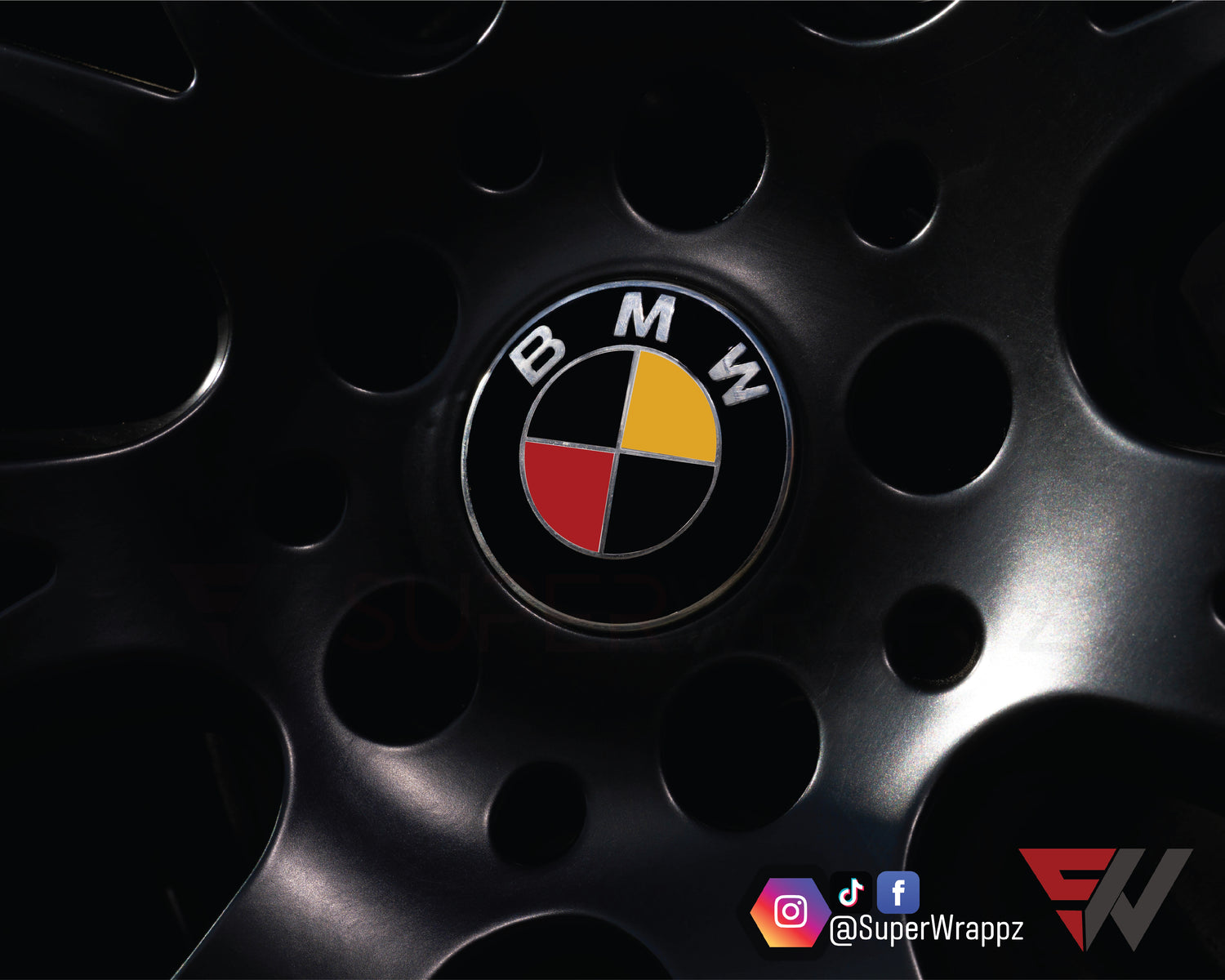 Germany & Belgium Flag BMW badge overlay on an alloy wheel centre cap, close-up