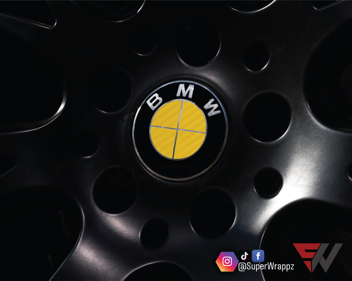 Full Yellow Carbon BMW badge overlay on an alloy wheel centre cap, close-up