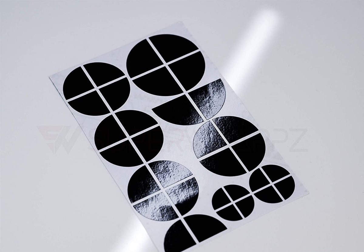 Half Black Gloss BMW badge overlay, shown uncut on its adhesive backing sheet before application