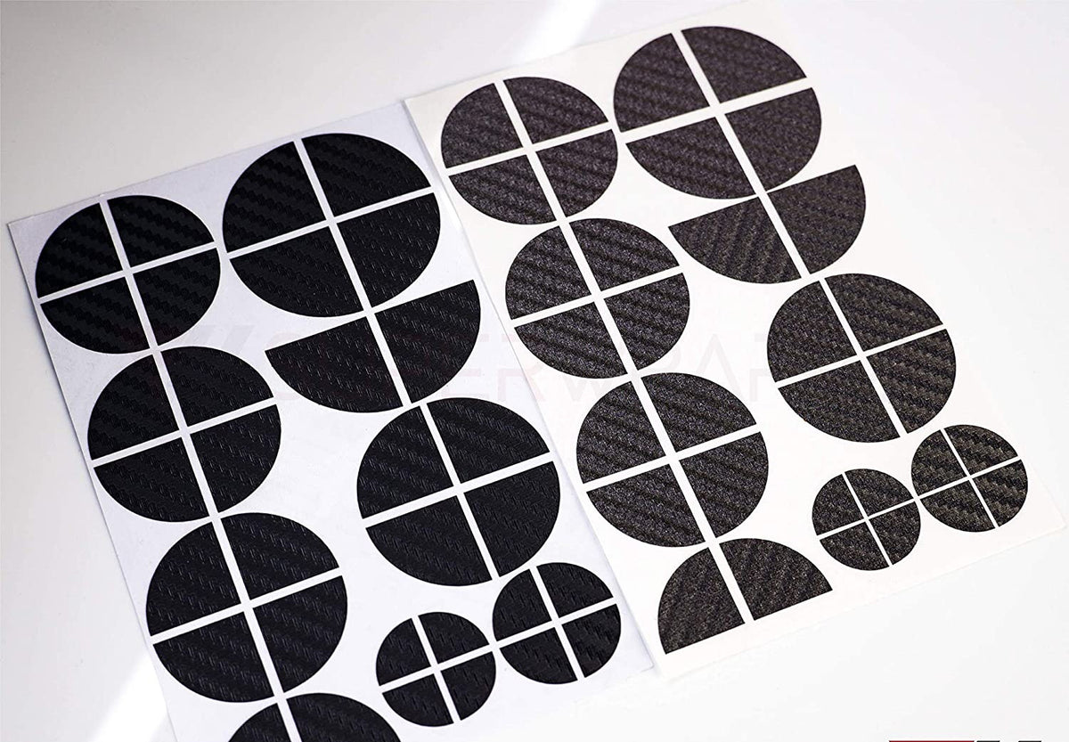 Black & Dark Grey Carbon BMW badge overlay, shown uncut on its adhesive backing sheet before application