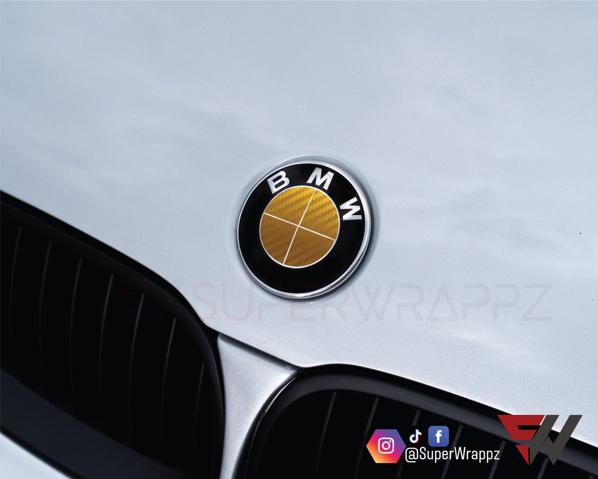 Full Gold Carbon BMW badge overlay applied to the front hood badge, close-up
