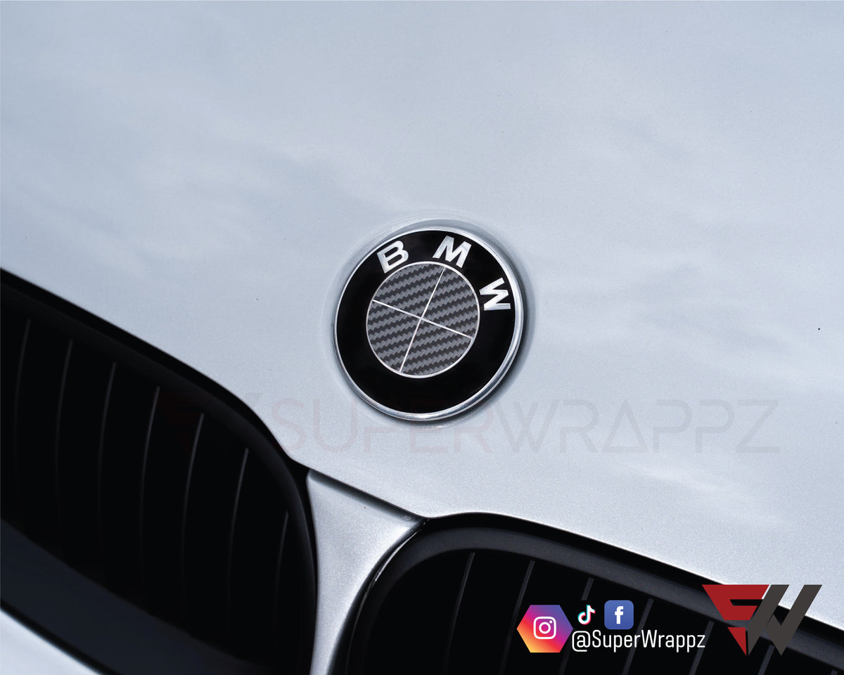 Full Dark Grey Carbon BMW badge overlay applied to the front hood badge, close-up