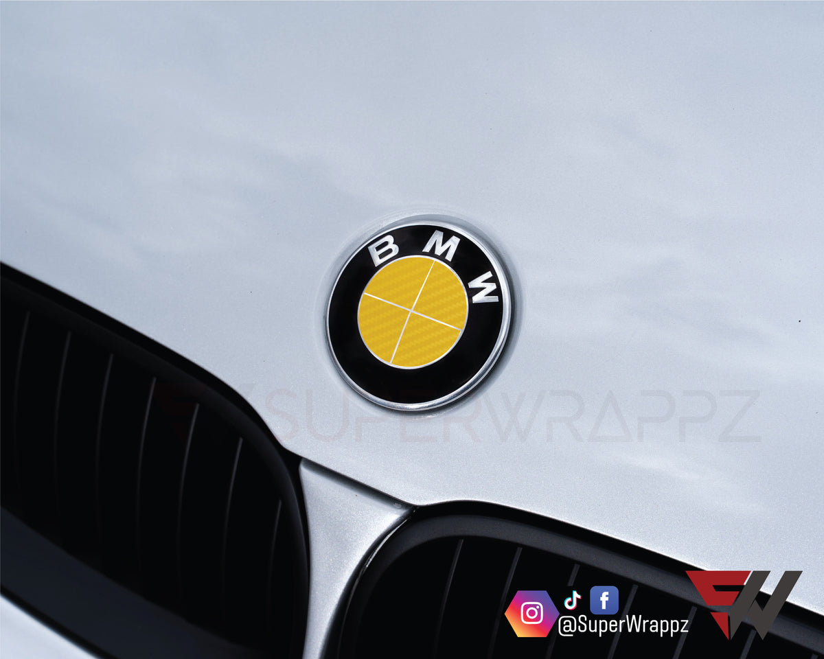 Full Yellow Carbon BMW badge overlay on the front hood badge, close-up