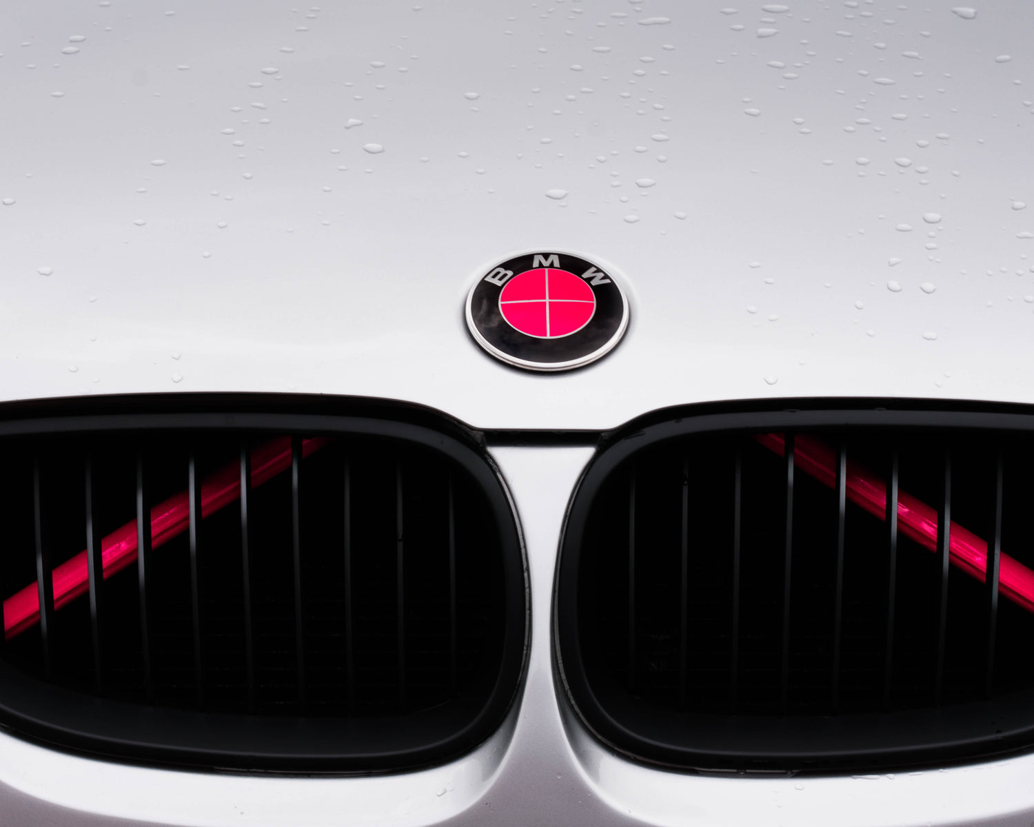 Close-up of a BMW front grille with the pink reflective V-brace installed