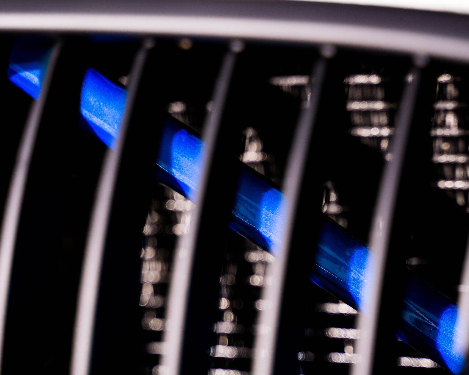 Close-up of a BMW front grille with the blue reflective V-brace installed