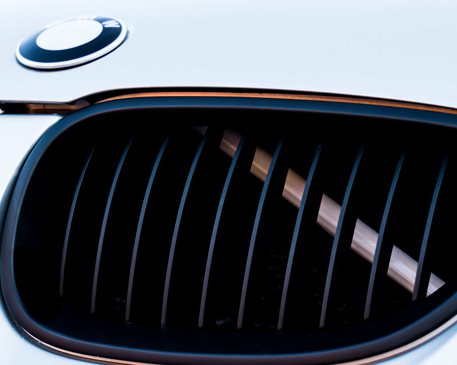 Close-up of a BMW front grille with the white reflective V-brace installed