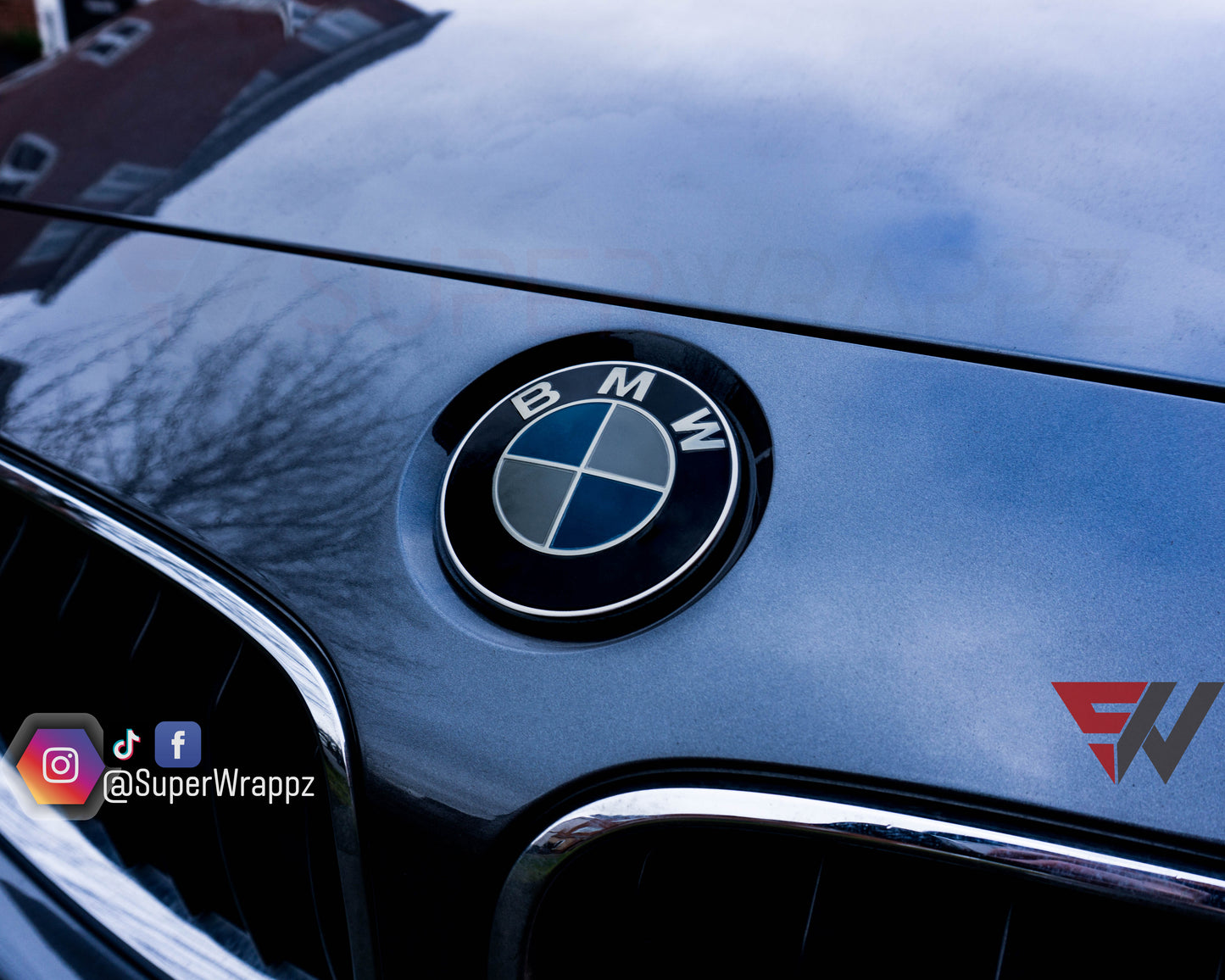 Light smoke 2-piece BMW badge tint overlay by SuperWrappz on E/F Series emblems, aftermarket vinyl
