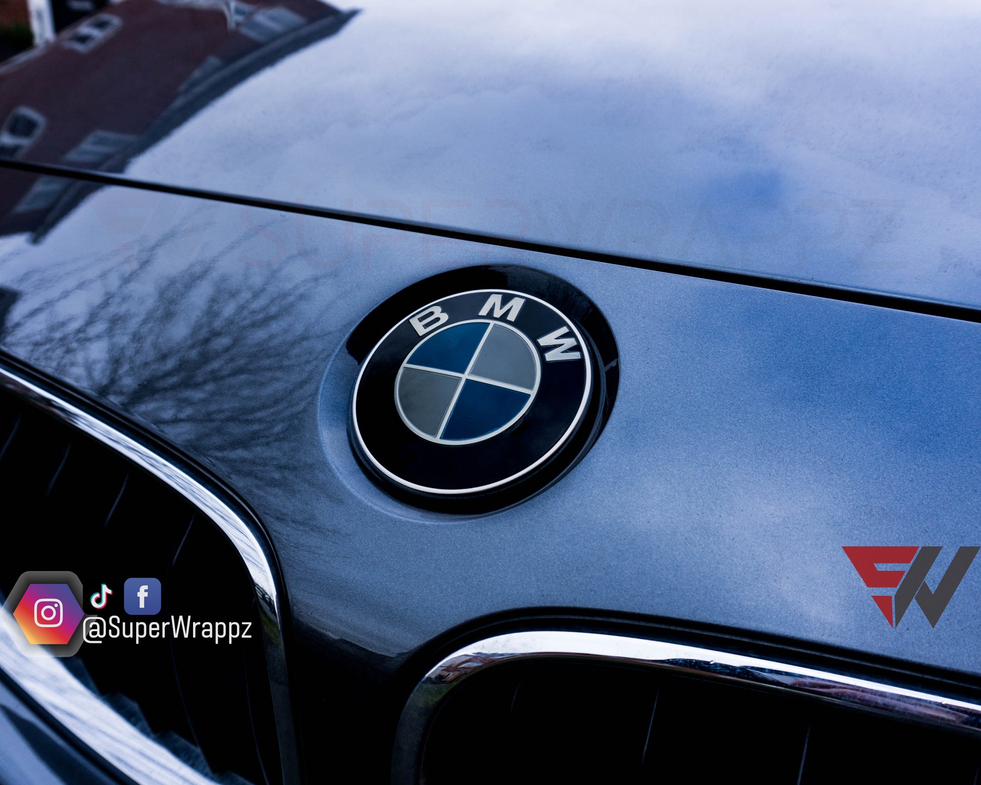 Light smoke 2-piece BMW badge tint overlay by SuperWrappz on E/F Series emblems, aftermarket vinyl