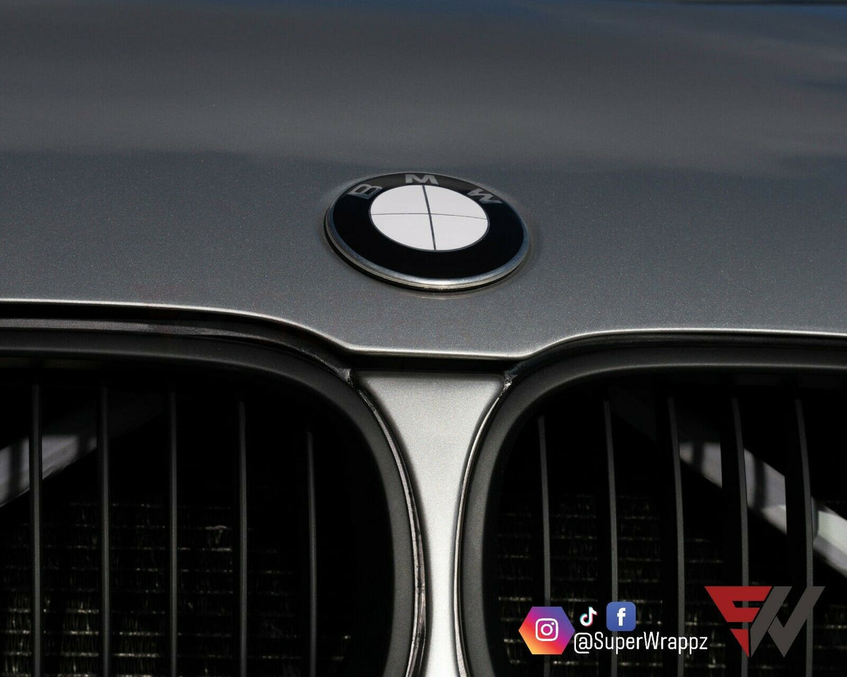 Full White Gloss BMW badge overlay applied to the front hood badge, close-up