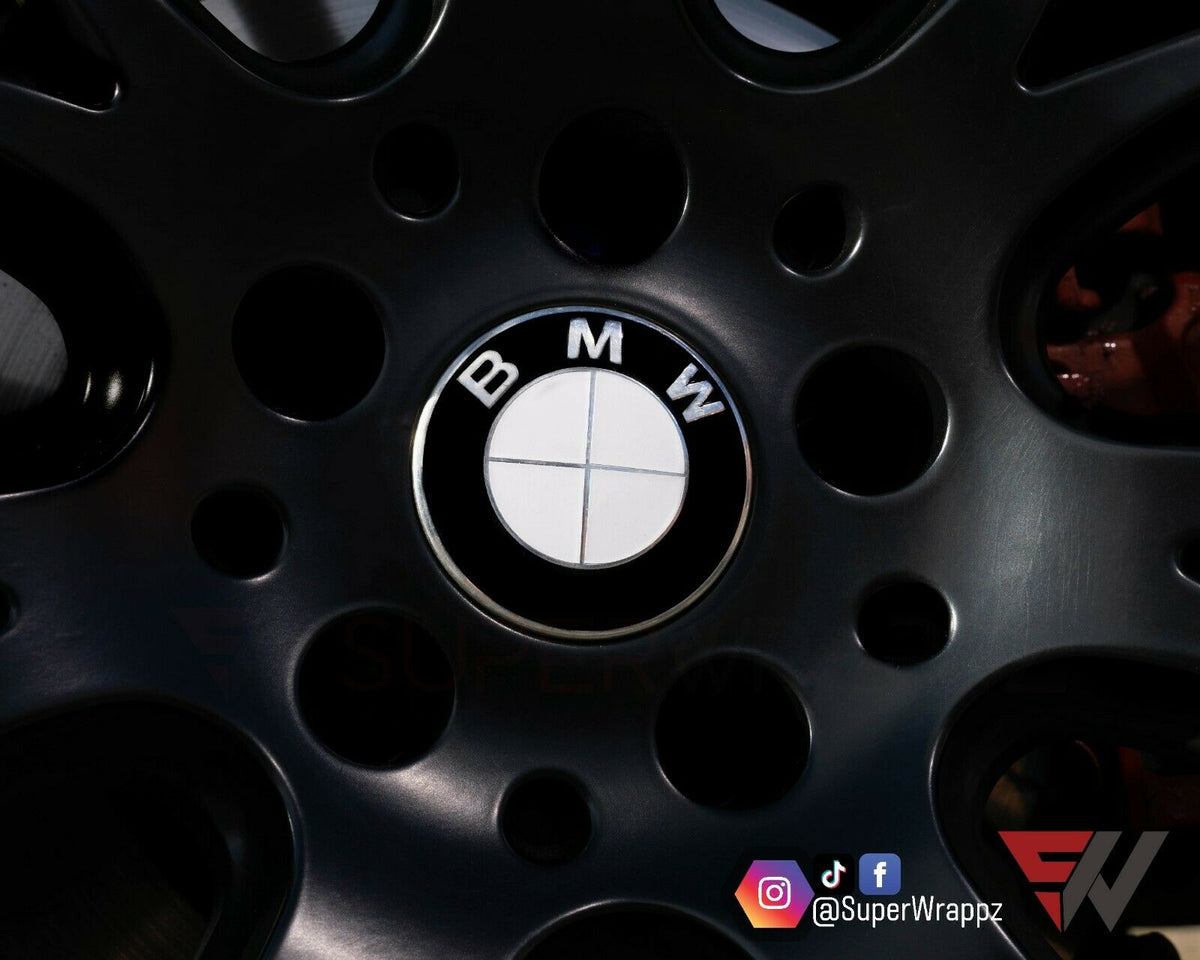 Half White Gloss BMW badge overlay applied to an alloy wheel centre cap, close-up